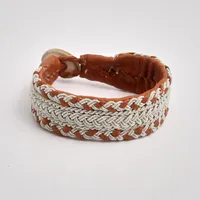 Armband i läder, Sameslöjd, med flätad tenndekor, knapp i horn, längd 18 cm, bredd 20mm