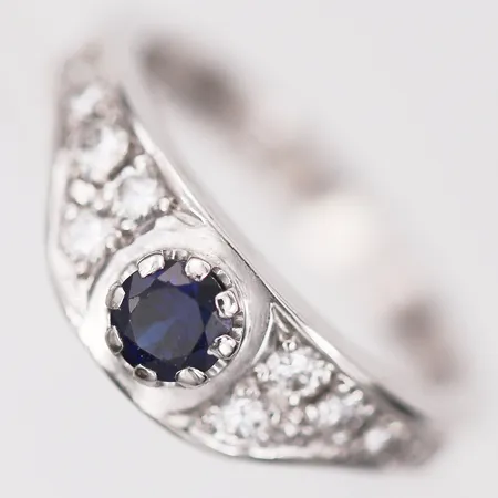 Ring med safir samt diamanter 6 x ca 0,04ct, 2 x ca 0,03ct, 1 x ca 0,005ct, stl: 17¼, bredd: 3-7mm, år 1990, 18K vitguld Vikt: 7 g