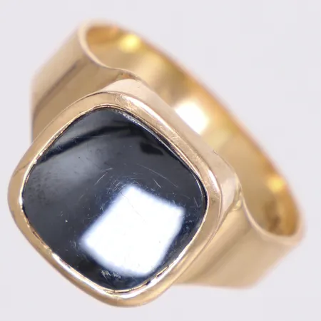 Klackring med hematit, stl 19, bredd 4-12,7mm, Anette Heyman Metall, Stockholm, 18K Vikt: 8,3 g