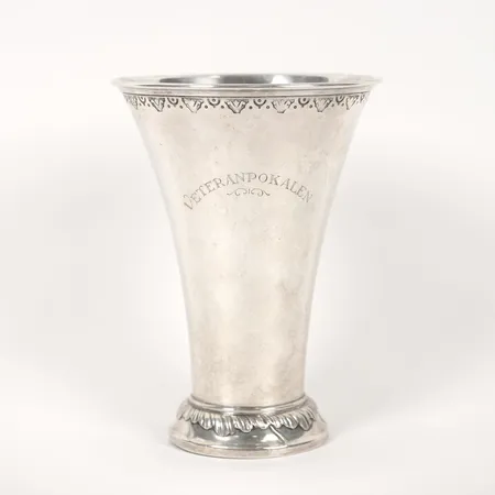 Bägare, nedåt avsmalnande form, vid kanten en stansad lambrekängbård, CG Hallberg, Stockholm, 1920, höjd 20cm, slitage, gravyr, märken, silver.   Vikt: 306,7 g