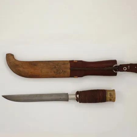 Samekniv, längd ca 29cm, dekorerad slida i läder samt trä, skaft av ben samt ben, bladets längd 15cm, defekt skaft, signerad 