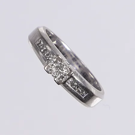 Ring med prinsesslipade diamanter totalt 0,30ctv enl. gravyr, stl 17¾, bredd 4,5mm, vitguld 18K Vikt: 7,1 g