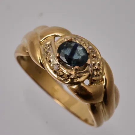 Ring i 18K guld, stl 16¾, bredd 2,7-8,3mm, 1st troligen safir, med mörkare parti i mitten,  mått 4x5mm, 2st små diamanter, 8/8 slipade, vikt 3,16g.