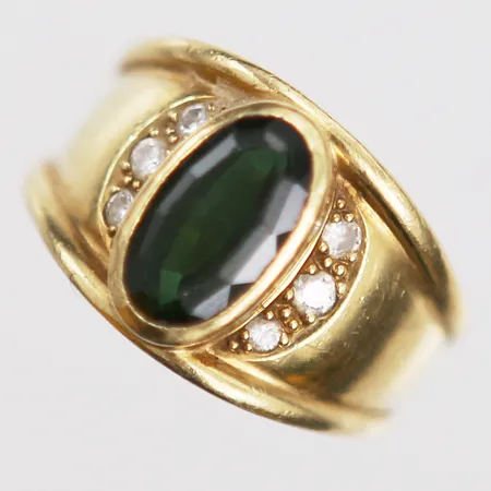 Ring med oval fasetterad turmalin, samt diamanter 4 x ca 0,02ct samt 2 x ca 0,03ct, stl 18¼, turmalin med slitage, 18K guld. Vikt: 10,4 g