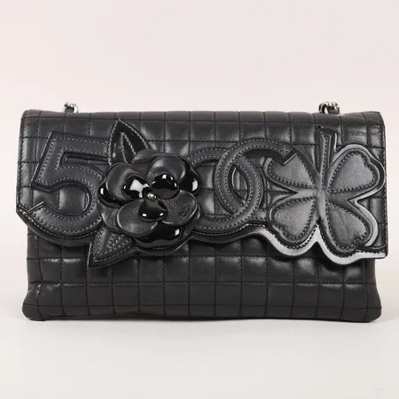 Handväska Chanel No 5 Camellia bag, svart lammskinn med silverfärgade beslag, invändigt fack varav ett försett med dragkedja, serienummer 10277399, saknar certifikat, ca 24x14x4cm, originalkartong, smärre slitage, märken/ytliga fläckar invändigt, kartong med märken/fläckar.     Skickas med postpaket.