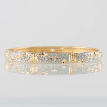 Armring mönstrad med genombruten dekor, märkt T381,  innerdiamater ca 66mm, bredd 7,3mm, 18k  Vikt: 11,3 g
