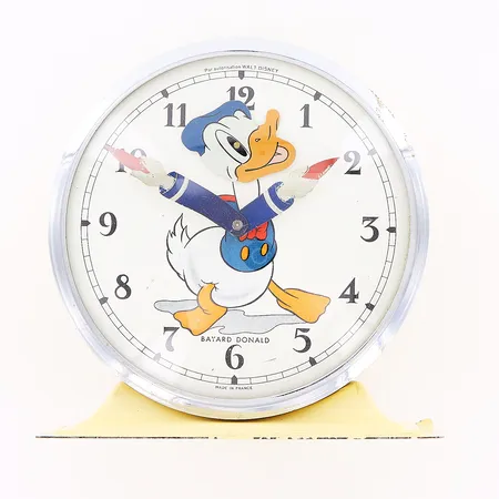 Väckarklocka i plåt, Bayard made in France, Kalle Anka, Walt Disney, 1950/1960-tal, fungerar ej/urverk i behov av service, höjd 12cm, bredd 12cm, Ø11cm, åldersbetingat skick.