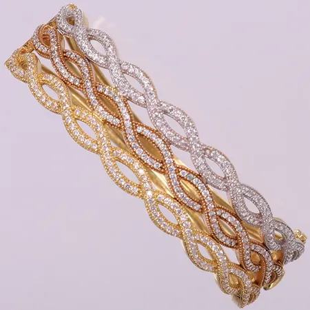 Stelt armband trefärgat med vita stenar, ca Ø58mm, bredd 7-11mm, en sten saknas. 18K Vikt: 23,3 g