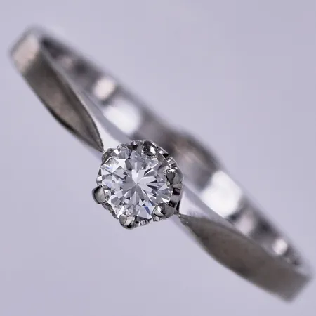 Ring med diamant ca 1x0,12ct, nagg på gördel och vid ena klon, stl: 16½, bredd: ca 1,5-3mm, 18K  Vikt: 1,7 g