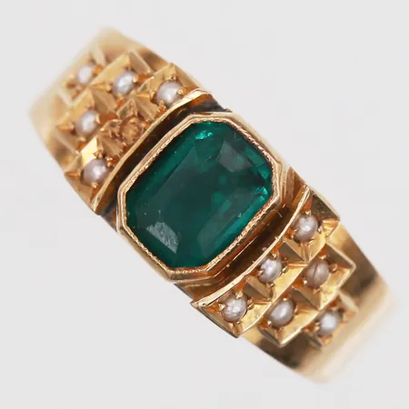  Ring med grön sten och 11 fröpärlor, en fröpärla fattas, stl: 17 ¾, bredd 1,5-4,6mm, åldersbetingat slitage, 18K guld.  Vikt: 2,8 g