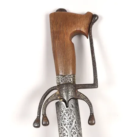 Nimcha, marockansk, 1800-tal, järnfäste med koftgari-arbete, grepp av horn, textilklädd balja med beslag sannolikt av låghaltigt silver, längd 99cm, inklusive balja ca 104 cm, bruks- och åldersbetingat slitage, balja med skador. Vikt: 0 g Skickas med postpaket.
