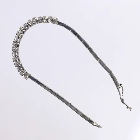 Armband med diamanter 24x ca 0,04ct samt 12 blå stenar troligen safirer, halvstelt, 18cm, bredd 4-6mm, vitguld 18K Vikt: 19,8 g