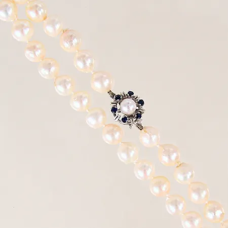 Pärlcollier med odlade sötvattenpärlor, längd 57cm, Ø7,5mm, lås i vitguld med safirer, pärlor med slitage, vitguld 18K.  Vikt: 43,9 g