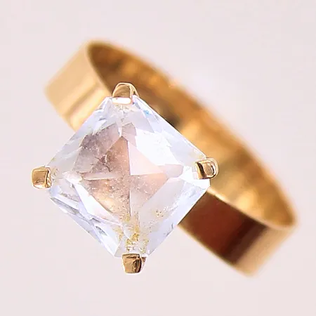 Ring med vit sten, stl: 16, bredd 5-7,5mm, 18K.  Vikt: 2,3 g