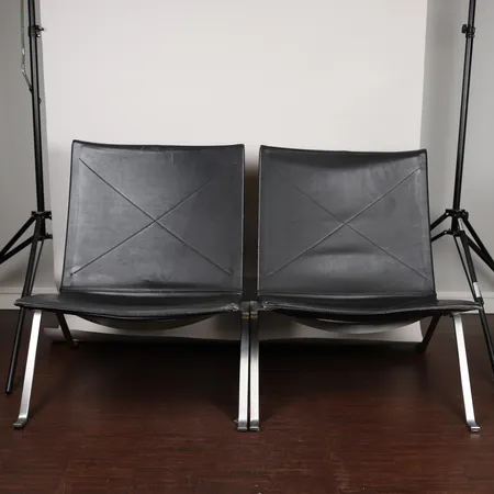 Ett par fåtöljer, modell PK-22,  Poul Kjaerholm för Fritz Hanszen, svart läder, sitthöjd ca 35cm, kantskador, mindre reva, bruksslitage.   Specialfrakt, kontakta pantbankskontoret för mer information.