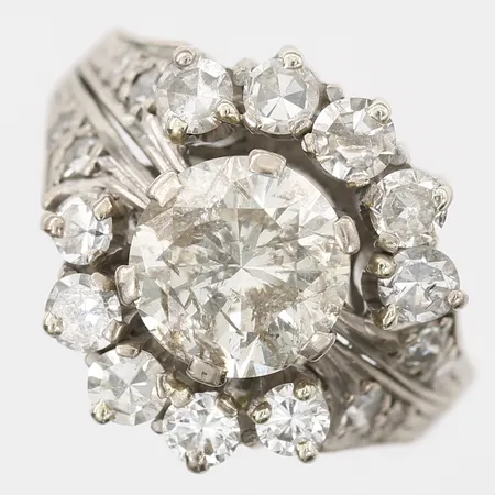 Ring med briljantslipad diamant ca 2,50ct, kvalitet ca Ca (N-O) /P2, inneslutningar som når ytan, sidostenar totalt ca 1,00ct, blandade slipningar, stl: 16½, 18K vitguld, vikt 9,4g Vikt: 9,4 g