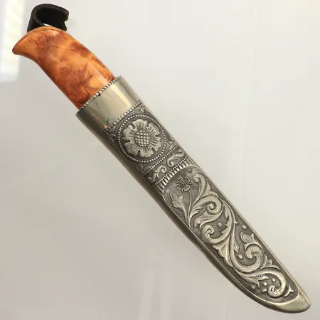 Kniv med björkskaft, blad i stål, slida i dekorerad tenn, handsmide, Norge/ Norway 53,TK, Haugrud, längd ca 23cm, inklusive slida, enbart kniv, blad ca 10cm, skaft ca 21cm, slitage på skaft, färgbortfall, bucklor, skador på slida, hållare i läder har gått av