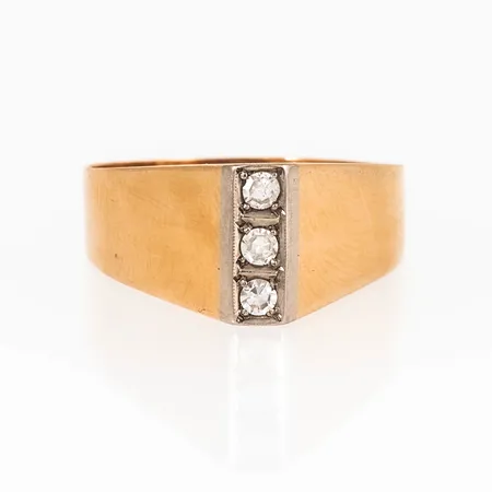Ring i 18K guld med tre åttkantslipade diamanter á c:a 0,03ct. Den är 3 - 9,3 mm bred och väger 3,4g. Tillverkad 1964 av  Guldateljen Fryklund & Pålsson  i Stockholm. 