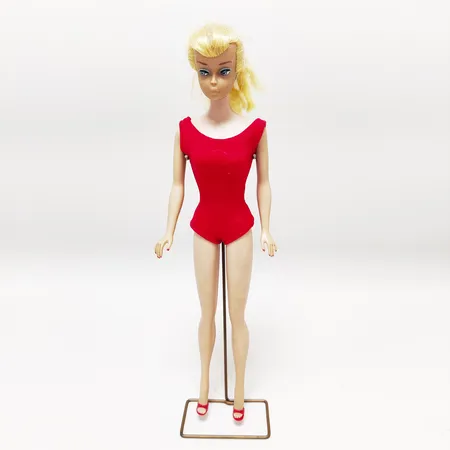 Barbiedocka, #850 Platinum Swirl Ponytail, tillverkades år 1964-1965, märkt Midge T. M. ©1962 Barbie® © 1958 by Mattel, Inc. Patented, ordet "patented" lades till år 1964, komplett med röd baddräkt, röda klackskor med öppen tå, metallstativ, missfärgade örsnibbar, färgbortfall ögonfransar, metallstativ, inga övriga tillbehör. Vikt: 0 g
