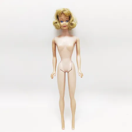 Barbiedocka, #860 Midge, straight leg freckles, blond, tillverkades 1963-1966, märkt "Midge T. M. ©1962 Barbie® © 1958 by Mattel, Inc. Patented", ordet "patented" lades till år 1964, Barbies kompis Midge delar kroppsform och märkning med Barbie men har egen huvudform och kläder, inga tillbehör. Vikt: 0 g