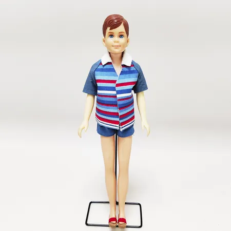 Barbiedocka, #1090 Ricky, Skippers kompis Ricky, endast tillverkad år 1965, märkt "©1963 Mattel, Inc.", komplett med blå strandjacka, blå bomullsshorts, och korksandaler, metallstativ, inga övriga tillbehör. Vikt: 0 g