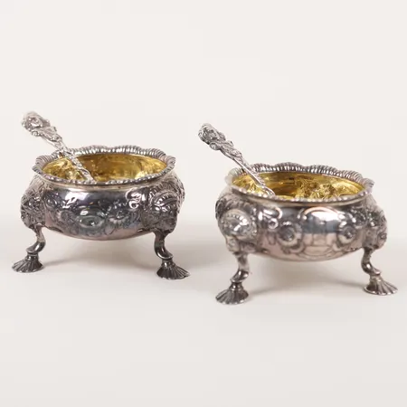 Ett par saltkar med crest, London England, troligen 1751, invändigt förgyllda, höjd 4,5cm, otydliga stämplar åldersbetingat slitage, bucklor, silver, ej från början tillhörande saltskedar av pläter medföljer.  Vikt: 173 g