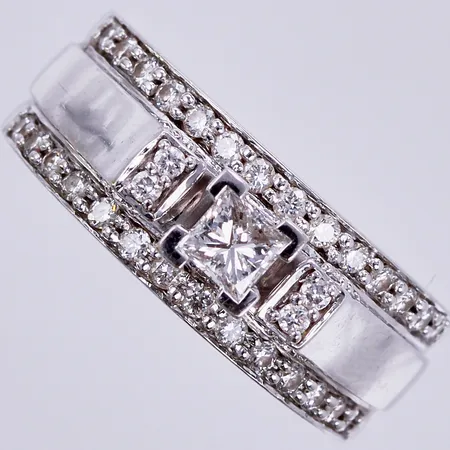 Ring med 1x0,10ct (princess), samt 32x0,01ct, graverad: 16 ¼, bredd ca 6-7mm, 18K Vikt: 6,1 g