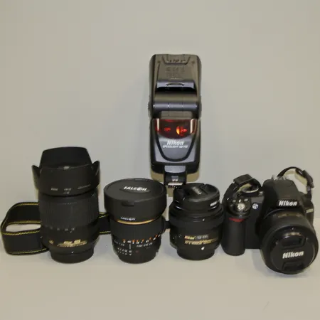 Systemkamera Nikon D3100, 4st objektiv samt blixt, Nikon DX AF-S Nikkor 35mm 1:1.8G, Nikon AF-S Nikkor 50mm 1:1.8G, Nikon DX AF-S Nikkor 18-105mm, Falcon Fish-eye C5 8mm 1:3.5, Blixt Nikon Speedlight SB-700, kameran saknar batteri och laddare, ej funktionstestad.  Skickas med postpaket.