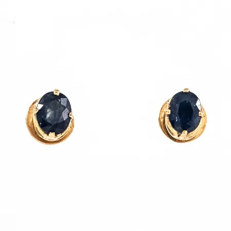 Örhängen i 18K guld med ovalslipad blå sten (safirer?). De är 6 x 4,7 mm och väger 1,4g. Gängade pinnar / snurrebussar med skruvmekanik.