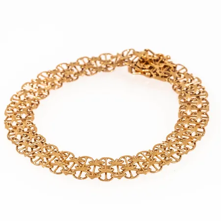 Armband X-länk med stav i 18K guld. Det är 9,5 mm brett, 19,5 cm långt och väger 12,2g. Kistlås. Tillverkat 1967 av Styletta Guldvaruaktiebolaget i Stockholm. Stämplat 18K & Kattfot. 