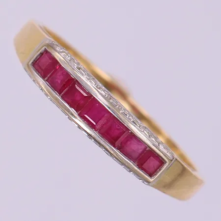 Ring med troligen 7 prinsesslipade rubiner samt 8/8-slipade diamanter 14 x ca 0,0075ct, stl: 22, bredd 1,5-4,5mm, fattning i vitguld, 18K.  Vikt: 3,2 g