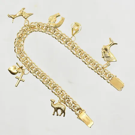 Armband med 6 berlocker, längd 18½ cm, bredd 8 mm, 18K. Vikt: 25,1 g