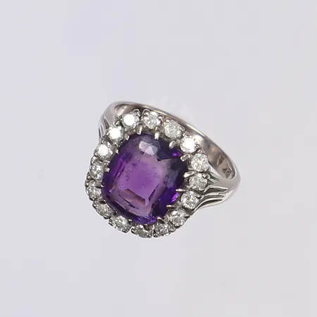 Carmoséring med diamanter totalt ,081ctv enl. gravyr samt lila sten, stl 18½, bredd 3-17mm, påtagligt slitage, vitguld 18K Vikt: 9,8 g
