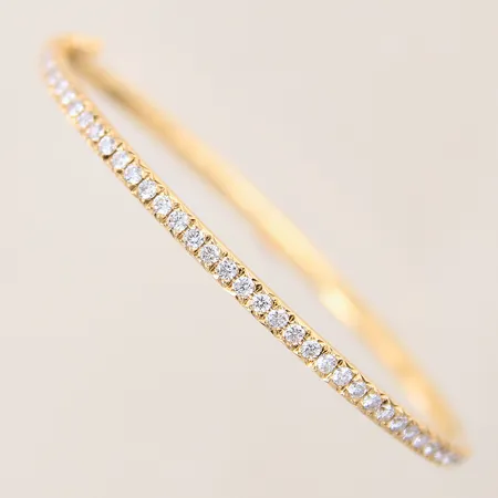 Armring med diamanter 40 x ca 0,02ct, fem stycken av diamanterna indikerar på att vara syntetiska, öppningsbar, Ø53x46mm, bredd 3mm, 18K  Vikt: 13,7 g