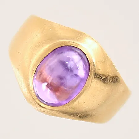 Ring med en cabochonslipad syntetisk lila safir, stl 15¼, bredd 4-12mm, sten med slitage, något repig skena, 18K  Vikt: 2,7 g
