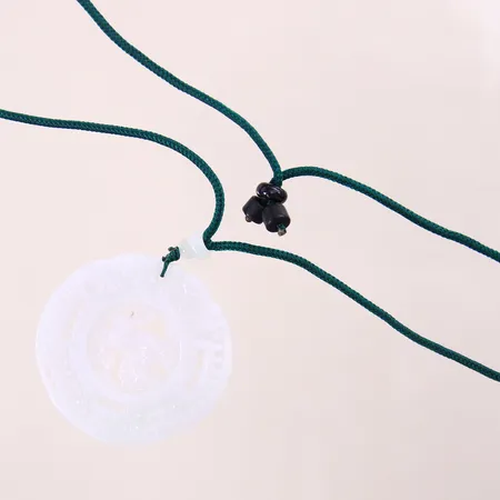 Collier i textil med integrerat hänge i jade, längd ca 60cm, bredd 2mm, hängets mått Ø50mm, collier med ojämnheter, bruttovikt: 25,5g