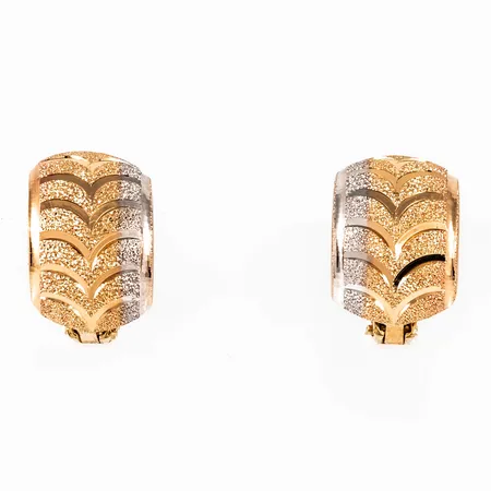 Örhängen i 18K guld. Breda halvcreoler med matterad mönsterdekor. De är 9,3 mm bred, 13,5 mm lång och väger 3,3g. Fällögla.