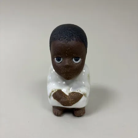 Figurin "Syd", Lisa Larsson för Rörstrand, stengods, ur serien "All världens barn", höjd ca 10cm, signerad.