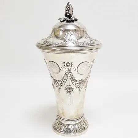 Lockpokal, repoussédekor samt 2-kronor, Oscar II, "Tjugufemårig regering" 1872-1897, lock krönt av druvklase, höjd: 30,5cm inklusive lock, ograverad, K Anderson, Stockholm, 1898, lock något skevt, ligger ej dikt an mot pokalen, 830/1000 Vikt: 764,6 g