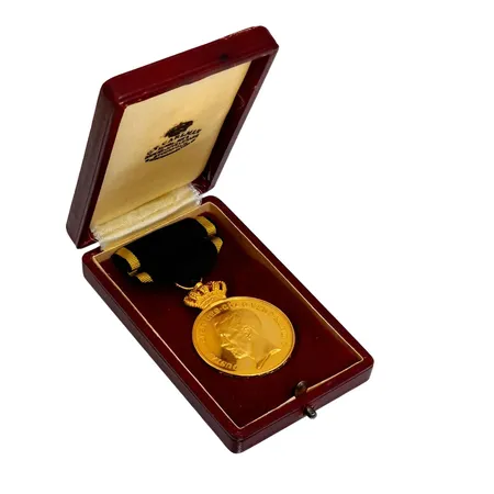 Guldmedalj "FÖR TROHET OCH FLIT" PRO PATRIA, Gustaf V, 23 K guld (krona i 18K guld), Ø33,5 mm, namngravyr på kantrand, etui, bruttovikt inkl. band 33,2 gram