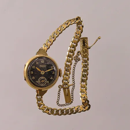 Damur Tissot 18K, 19mm, länk i 18K, totallängd ca 16cm, monogram, 18K bruttovikt 14,4g.
