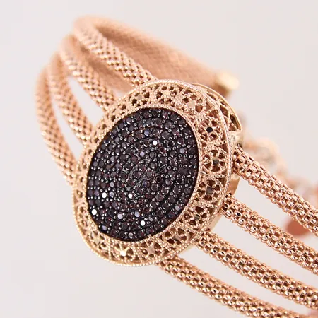 Armband med mörka stenar, Ø56,5mm, bredd 13,8-26,2mm, rödguld 14K.  Vikt: 22,7 g