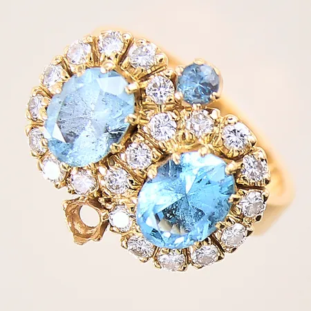 Ring med briljantslipade diamanter 21xca0,03ct samt troligen blå topaser, stl: 17¾, bredd: 4,8-12,7mm, en sten saknas, ett fåtal slitna klor, 18K  Vikt: 9,4 g