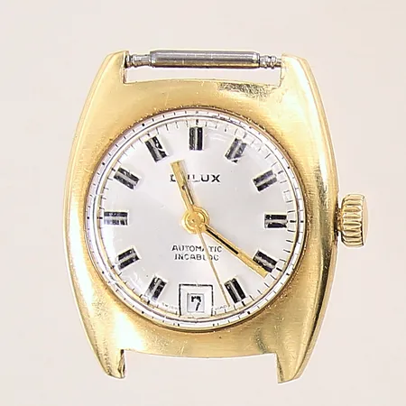 Damur Dulux, Ø25mm, automatisk, boett i guld, serienummer: 10051, repigt glas, går ej, 18K bruttovikt: 17,6g. 