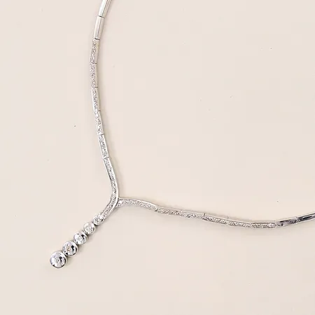 Collier halvstelt, med diamanter ca 4x0,03ct, 1xa0,02ct, 46x0,01ct, 42,5cm, bredd 2,2-6,5mm, hängets längd ca 43mm, vitguld, 18K Vikt: 24,8 g