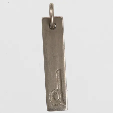 Hänge, "d", Ateljé Maria Söderholm, Stockholm år 2006, höjd inkl. ögla: 29 mm, bredd: 6 mm, 18K vitguld. Vikt: 4,7 g