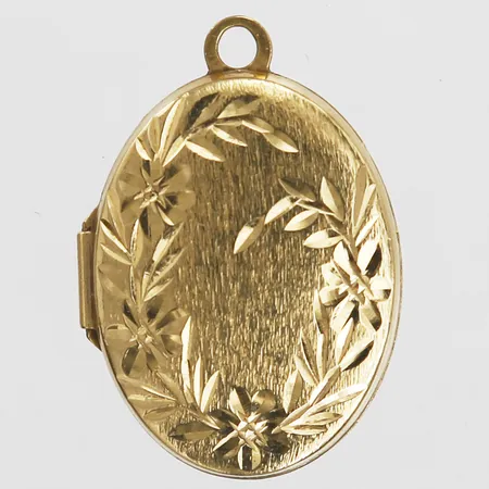 Hänge/Medaljong med snidad floral dekor, höjd inkl. ögla: 24 mm, bredd: 27 mm, mindre buckla på baksida, 18K guld. Vikt: 2,3 g