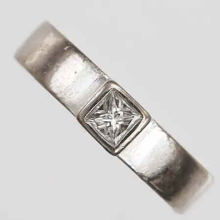 Ring med prinsesslipad diamant 1 x ca 0,24ct, samt briljantslipade diamanter 3 x ca 0,01ct, Anders Fors Guldateljé, stl: 15¾, bredd: 5 mm, gravyr, 18K vitguld. Vikt: 9,2 g