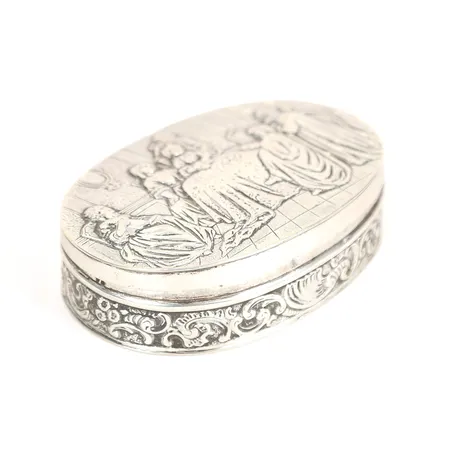Dosa, dekor i relief, lock med figurscen, längd 10,5cm, otydliga stämplar, silverpläterad, otydliga stämplar.