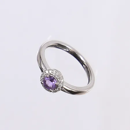 Ring med diamanter totalt ca 0,09ctv samt lila sten, stl 15, bredd 2-6mm, vitguld 18K Vikt: 2,3 g